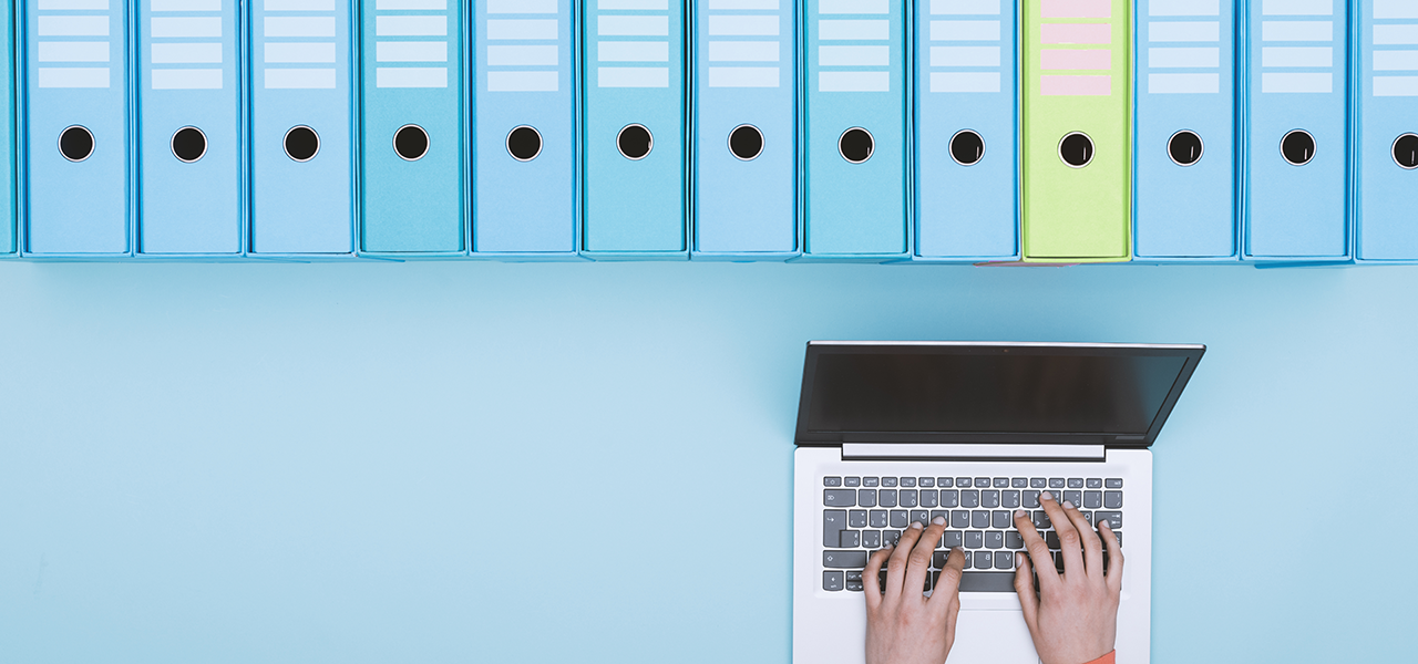 Frau sucht mit Laptop Dokumente